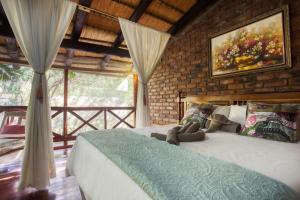 a bedroom with a bed and a painting on the wall at Doringpoort Lodge in Marloth Park +197 photos