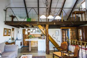 a living room with a loft with a staircase at Schaftplaas Cottages in Langebaanweg