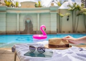 een hoed en zonnebril op een tafel bij een zwembad bij Meliá Campinas in Campinas +82 foto's