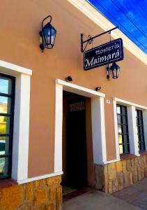 um edifício com uma porta preta e um sinal nele em Hosteria Maimará em Maimará