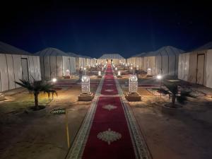 une longue rangée de lumières dans un bâtiment la nuit dans l'établissement Sahara Desert Luxury Camp, à Merzouga