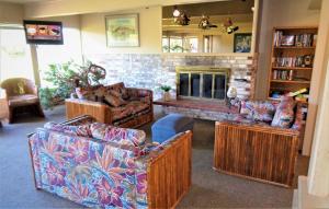 a living room with three couches and a fireplace at The Polynesian Resort in Ocean Shores