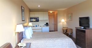 a small hotel room with a bed and a kitchen at The Polynesian Resort in Ocean Shores