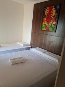 2 camas en una habitación con un cuadro en la pared en Morro Vermelho en Goiânia