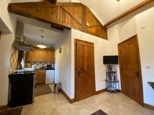 una cocina con armarios de madera y fregadero en Thompsons Arms Cottages, en Flaxton