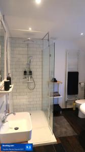 a bathroom with a glass shower and a sink at Boutique cottage in the heart of Winchcombe in Winchcombe