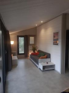 a living room with a couch and a table at Chalet la lande in Ondres