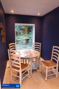 a dining room with a white table and chairs at Boutique cottage in the heart of Winchcombe in Winchcombe