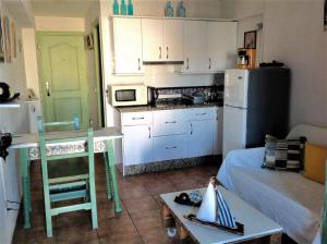 a small kitchen with a table and a refrigerator at The Studio in Benalmádena