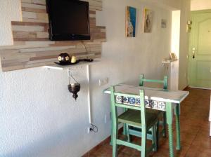 um quarto com uma mesa e uma televisão na parede em The Studio em Benalmádena