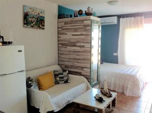 a room with a refrigerator and a table and a bed at The Studio in Benalmádena