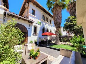 a building with a palm tree and a patio at Hotel CasaDeTodos in Santiago