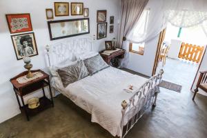 a bedroom with a white bed and a table at Schaftplaas Cottages in Langebaanweg