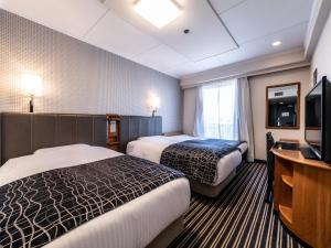 APA Hotel Kyoto Gion Excellent tesisinde bir odada yatak veya yataklar
