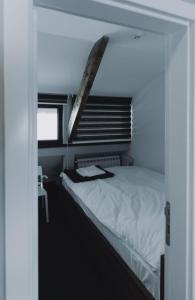 a bedroom with a white bed with a window at Mali Medved Konaci in Kopaonik