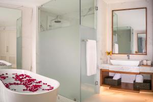 a bathroom with a tub with red flowers on it at Secrets Royal Beach Punta Cana - Adults Only in Punta Cana