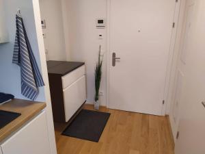 een keuken met een witte deur en een houten vloer bij Cosy Park Apartment City Center in Wenen