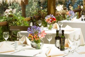 uma mesa com garrafas de vinho e flores num vaso em Termas de Jahuel Hotel & Spa em Santa María