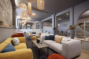 a living room with couches and tables and chairs at Rubin Hotel in Poreč