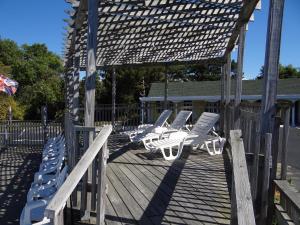 a deck with lounge chairs and a pergola at Jonathan Edwards Motel in Dennis Port
