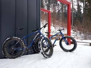 zwei Fahrräder, die neben einem Gebäude im Schnee geparkt sind in der Unterkunft Dom Pod Skałą in Jeleniów