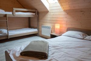 a bedroom with two bunk beds and a lamp at Amelia Domki in Sianozety