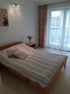 a bedroom with a bed and a large window at Maris Pokoje Gościnne in Łeba