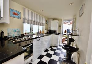 a kitchen with a black and white checkered floor at Boat House Sleeps 4 in the Centre of the Sailing Mecca of Cowes in Cowes