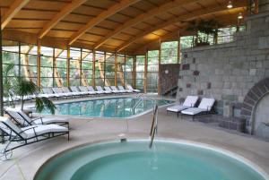 an indoor swimming pool with chairs and a building at Termas de Jahuel Hotel & Spa in Santa María