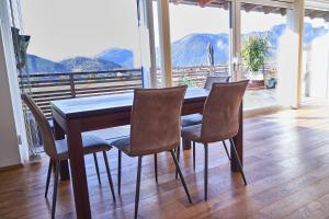 a dining room table with chairs and a view of mountains at Bergblick Acht Mondsee in Innerschwand am Mondsee