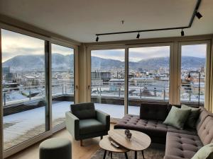 a living room with a couch and chairs and a large window at Veversmauet Apartments in Bergen