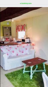 a living room with a white couch and a table at Maison Mai or La Petite Maison Mai or La Petite Grange or ALL three in La Chapelle-Urée