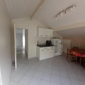 a kitchen with white appliances and a table in a room at UR ONDOAN - Appartement Saint Pée sur Nivelle in Saint-Pée-sur-Nivelle