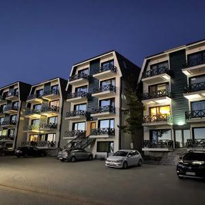 two cars parked in a parking lot in front of a building at Starloft Kopaonik in Kopaonik