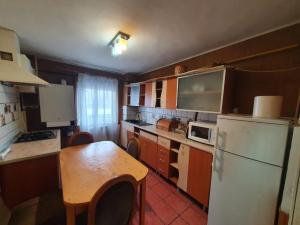 eine kleine Küche mit einem Tisch und einem Kühlschrank in der Unterkunft Casa Caprioara in Petroşani