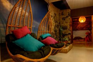 a room with two wicker chairs with colorful pillows at Hotel Tunebo Inn in Ríohacha
