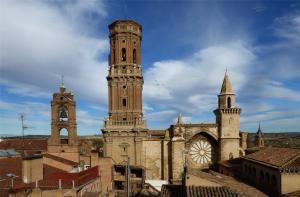 an old building with a clock tower and two other buildings at Carmen Alta in Tudela