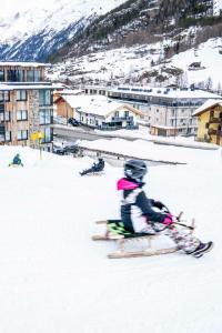 a person on skis in the snow in a town at Landhaus Martinus in Sölden