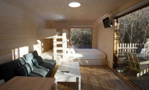 a bedroom with a bed and a couch and a table at Cabanas das Chousas in Lugo