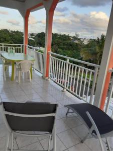 a balcony with a table and chairs on a porch at Loca Vacances in Sainte-Anne