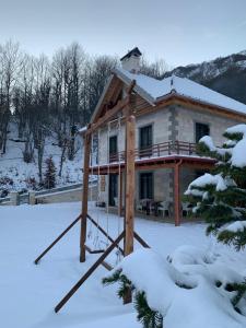 una baita di tronchi nella neve con neve di JOEN Village a Librazhd