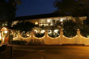 a white fence with christmas lights in front of a building at Malabar House in Cochin