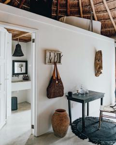 a living room with a table, chairs and a vase at NEST Tulum in Tulum