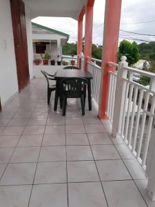 a patio with a table and chairs on a balcony at Loca Vacances in Sainte-Anne