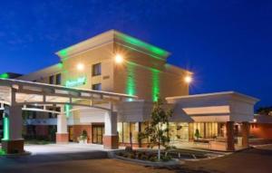 a large building with green lights on it at night at Holiday Inn Bloomington Airport, an IHG Hotel in Bloomington
