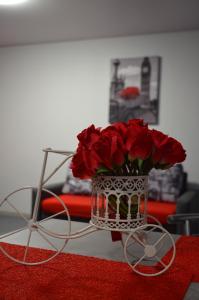 un jarrón lleno de rosas rojas sentadas en una mesa en Апартаменты на Александра Поля (Кирова) 90 en Dnipro