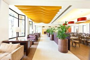 a restaurant with tables and chairs and a large yellow ceiling at Hotel Panamby Guarulhos in Guarulhos