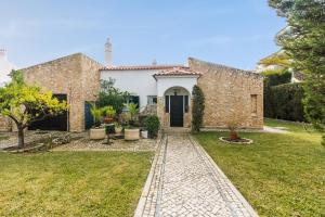 a stone house with a garden and a driveway at Oura Villa V3 com Piscina Privada in Albufeira