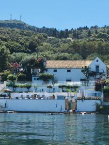 a white house on the shore of a body of water at Villa Evita in Mesongi