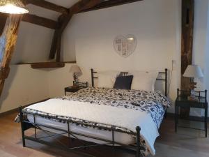 a bedroom with a bed in a room with wooden ceilings at au Petit Paradis in Sainte-Gauburge-Sainte-Colombe